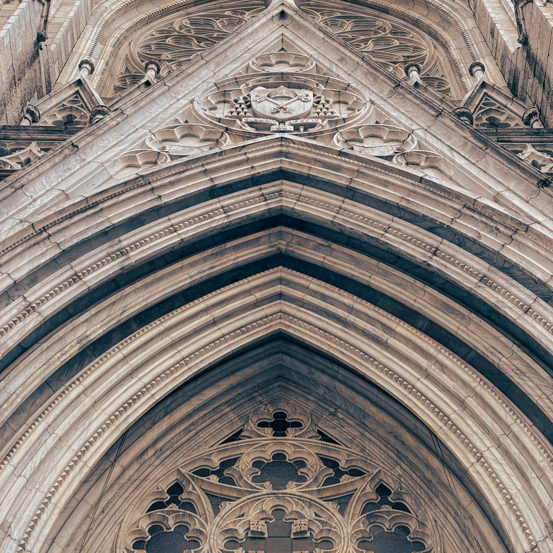 Looking straight up into the receding orders of a Gothic stone arch