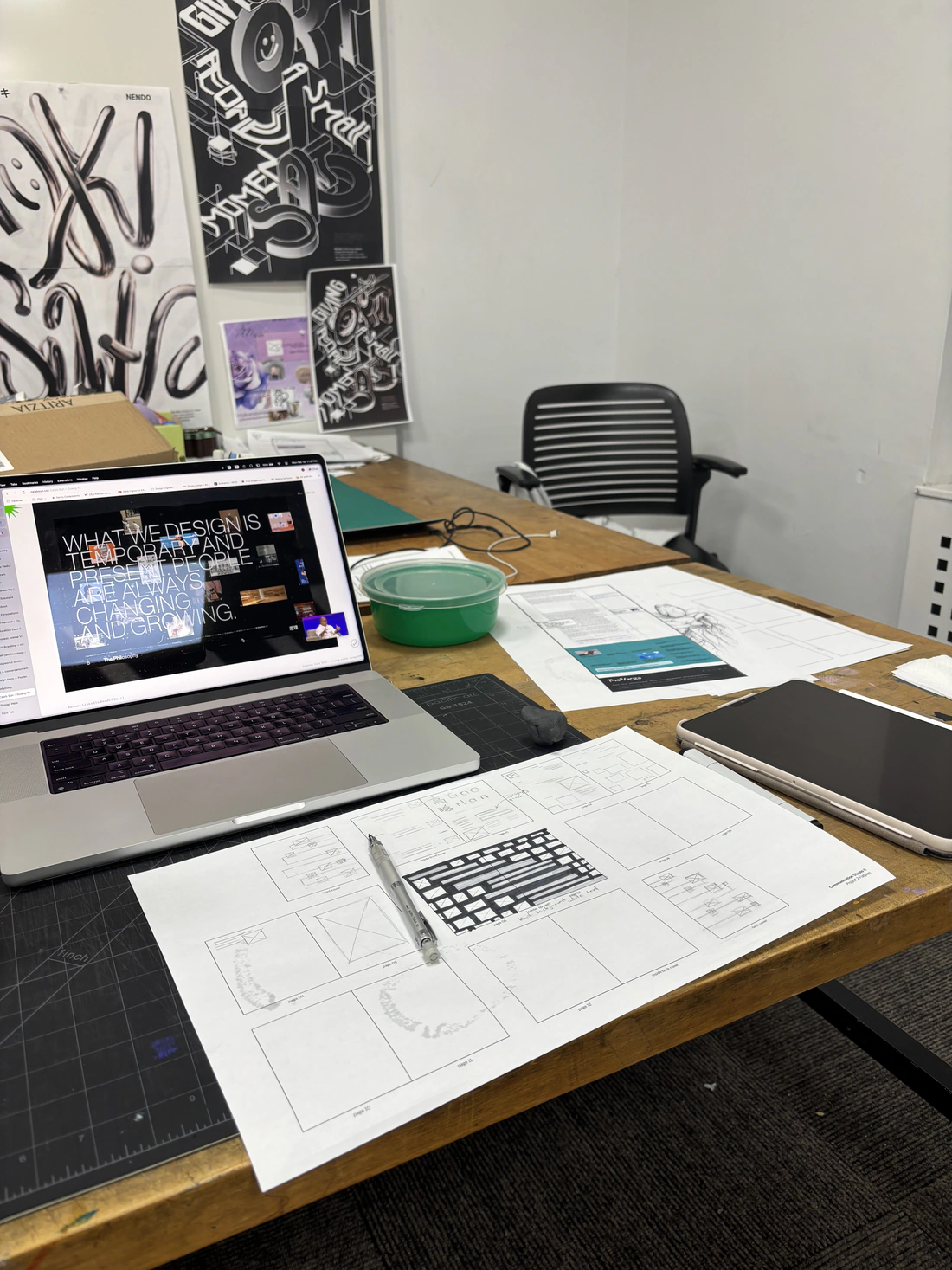 Desk with the booklet, laptop and poster proofs